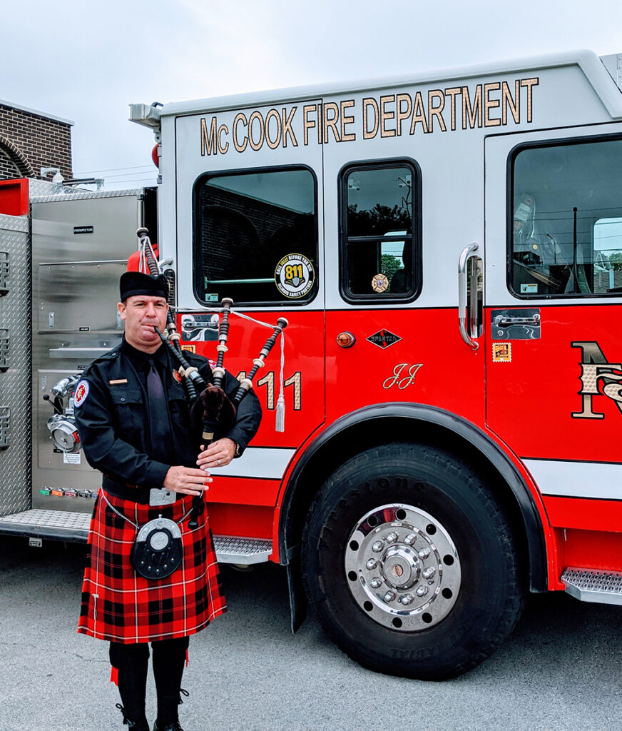 playing bagpipes in front of fire truck